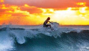 surfer on wave at sunset
